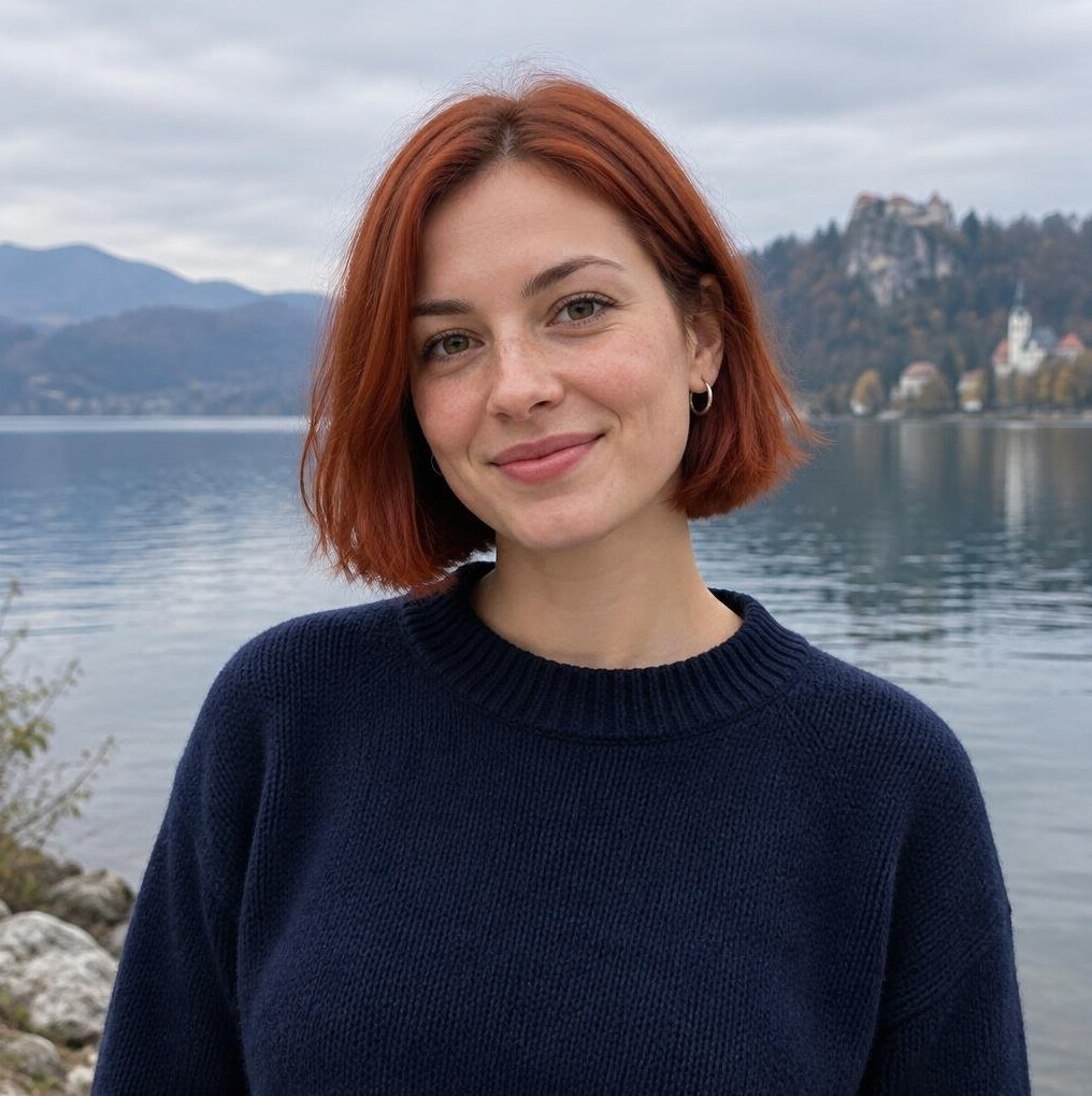 Woman with red bob haircut standing near water