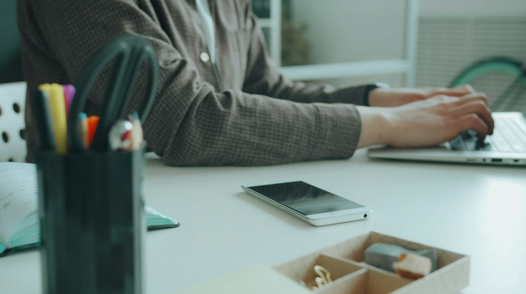 person writing email at desk
